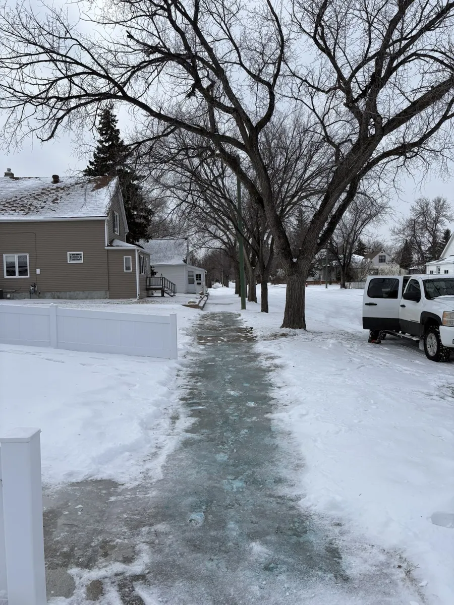 Cleared and ice-melted front sidewalk after snow removal in Moose Jaw Saskatchewan